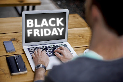 Hombre tecleando en un portátil con "Black Friday" en la pantalla