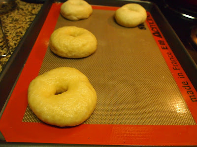 bagels are shaped and laid out on a baking sheet while you shape the rest of the doughs