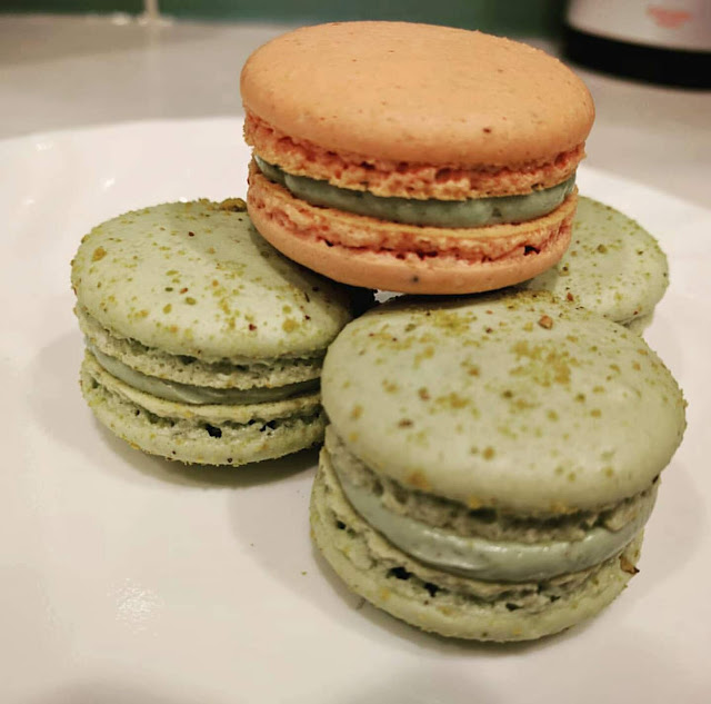 Pistachio and Strawberry Macarons filled with Pistachio Buttercream on a plate.