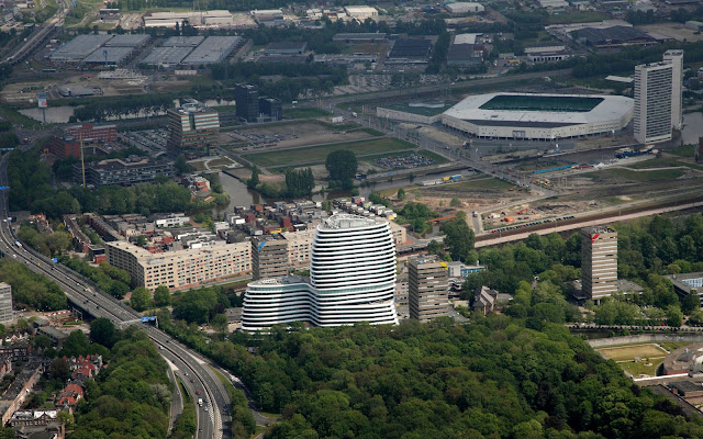 Picture of an office building as seen from the air with the rest of the city in the bacground