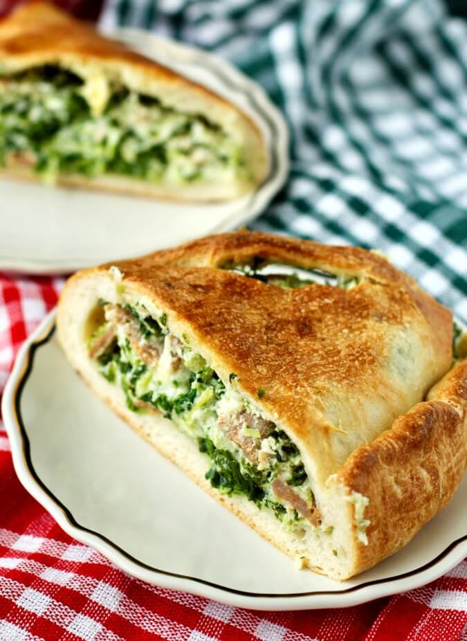 Calzones with ricotta, spinach, and sausage on plates