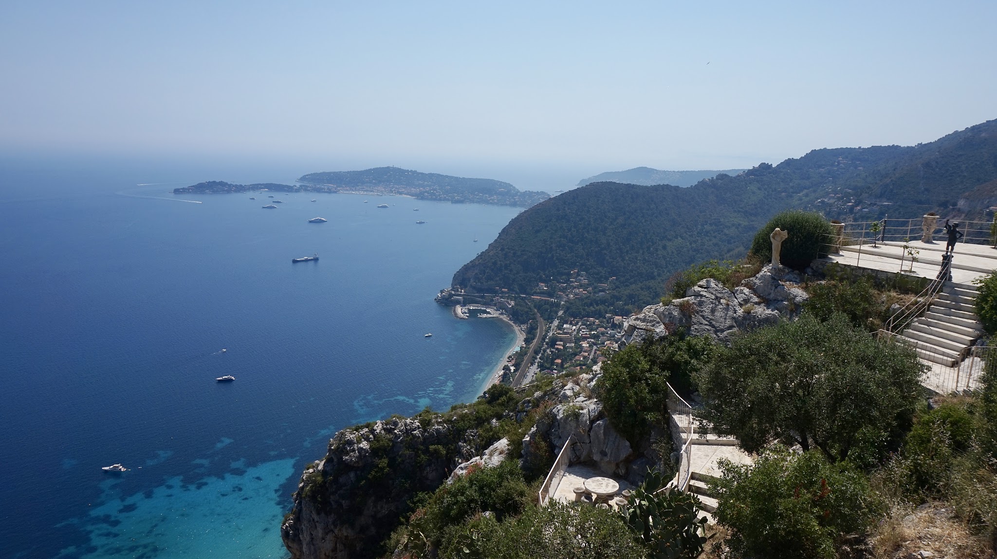 view down a cliff into the blue sea