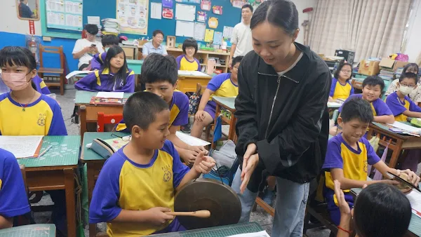 ▲大葉大學運健系二年級的周子安(站立者)幫助同學熟悉高甲戲曲樂器。（記者林明佑翻攝）