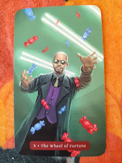 Card depicts a man dressed much like Morpheus from The Matrix, is he tossing candy or evading them?