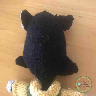 Picture of a close up of the back of a knitted black cat soft toy