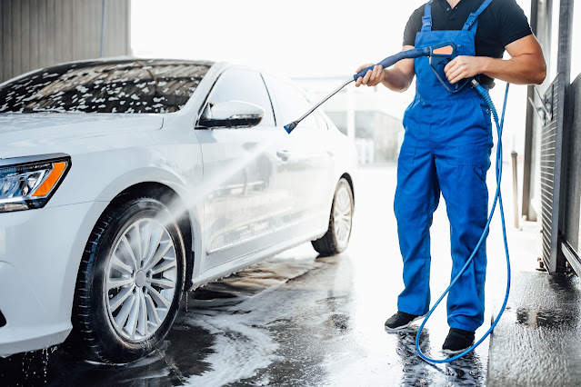 man Pressure Washing the car