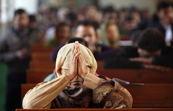 Mujer orando en iglesia bajo la persecución