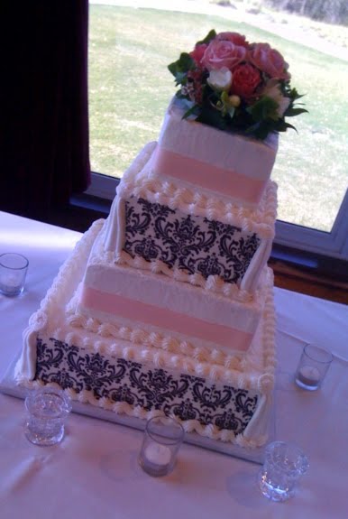 White cake with pale pink ribbon pink roses and black and white damask 
