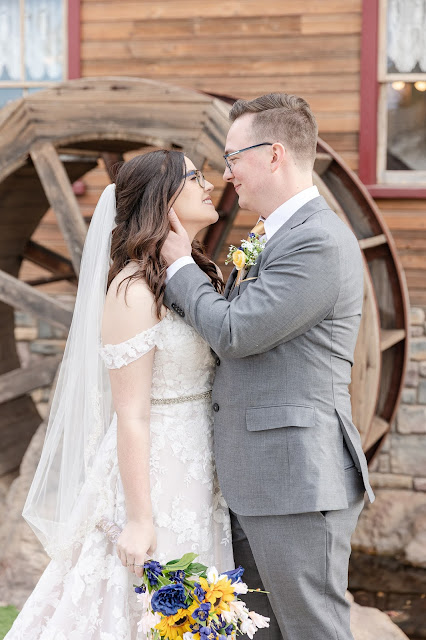 bride and groom in front of waterwheel