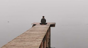 Man practicing mental relaxation by still waters