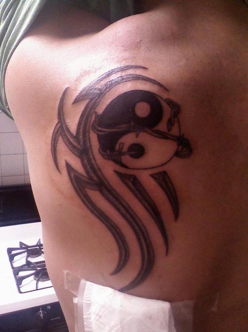 Tribal yin yang tattoo design on back left shoulder.