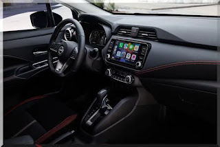 Detalhe da central multimídia do Nissan Versa 2024, com tela sensível ao toque e conexões Bluetooth e USB.