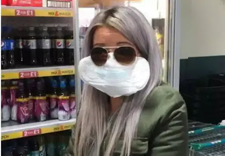 يا له من اختيار غير عادي! امرأة بريطانية ترتدي فوطة صحية على وجهها بعد أن نسيت حمل القناع