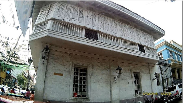 A Spanish mestizo building with adobe blocks in the bottom and wood on top  