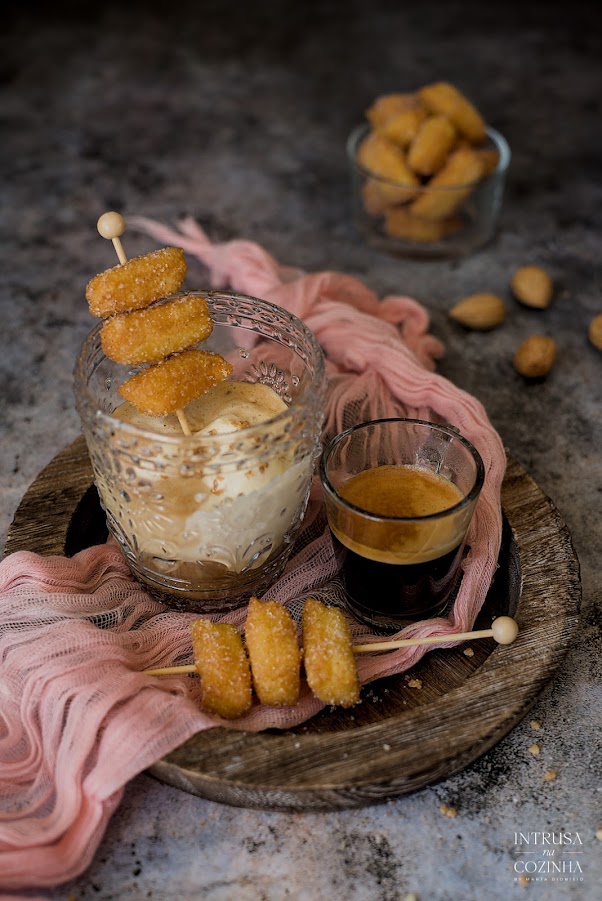 Um copo com Gelado e Café e uns churros espetados num pauzinho