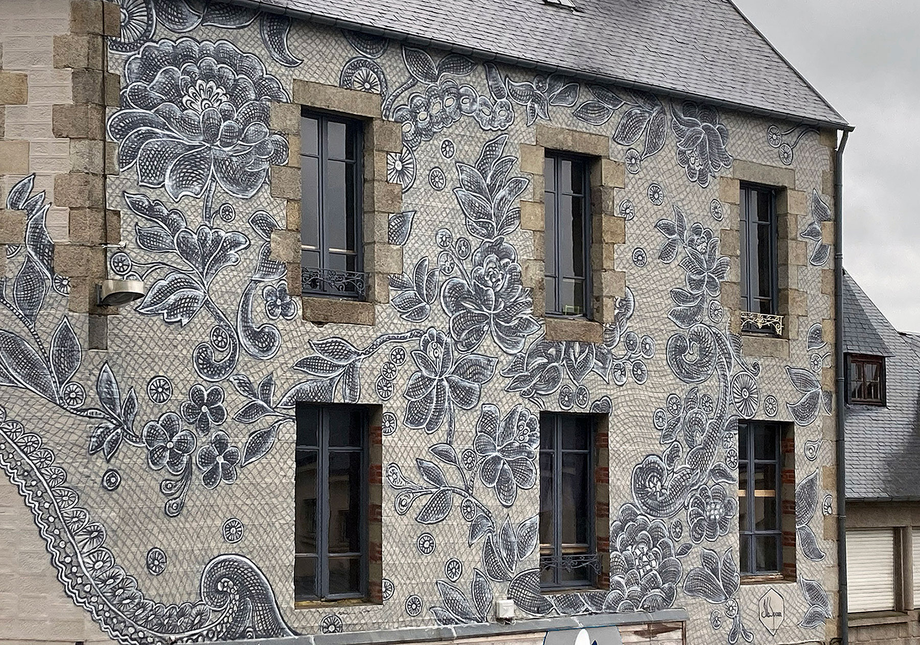 Delicados encajes pintados transforma la fachada de un edificio en Francia