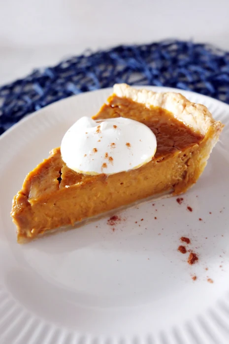 slice of pumpkin pie on plate with whipped cream