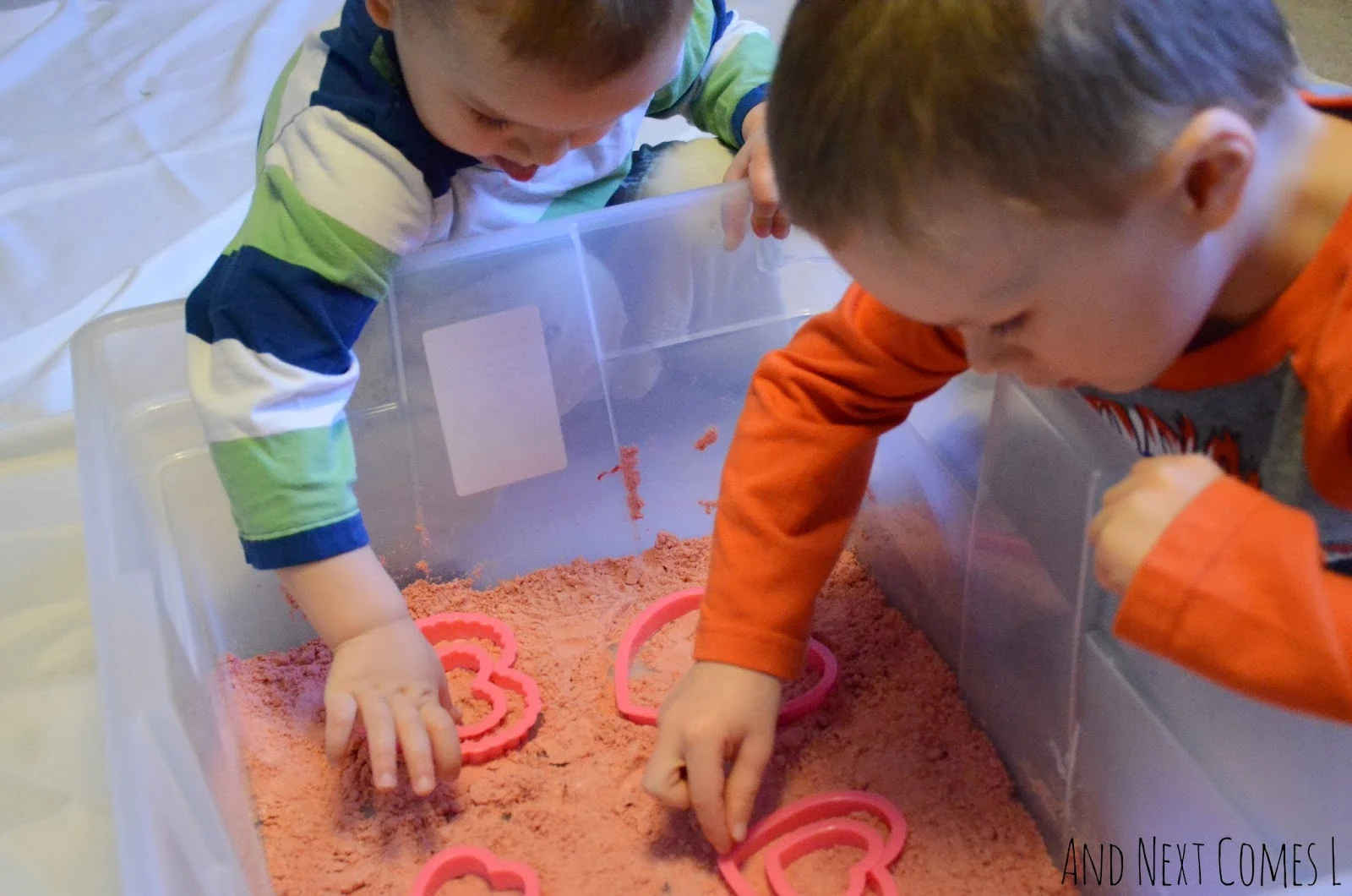 The boys checking out the cinnamon heart cloud dough sensory bin from And Next Comes L