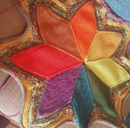 Starshaped blanket, the centre sections are all different colours following a rough colourwheel sequence. There are then rows that edge and go out from the star in a variety of colours.
