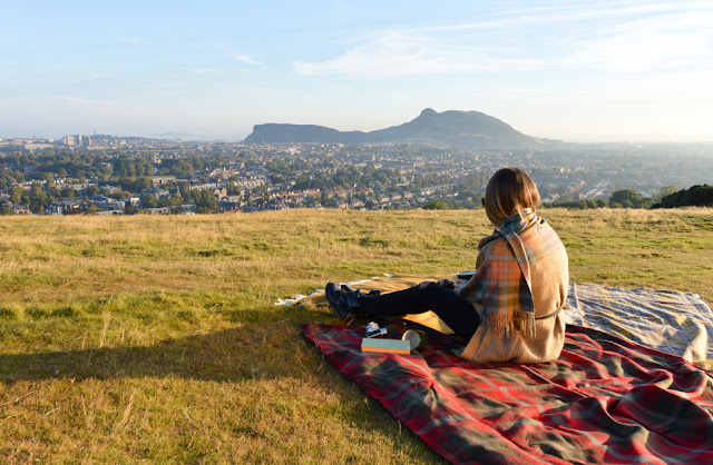 Chica en un picnic con un plaid rojo a cuadros