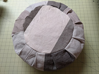 Top view of stuffed dark gray and off-white round meditation cushion