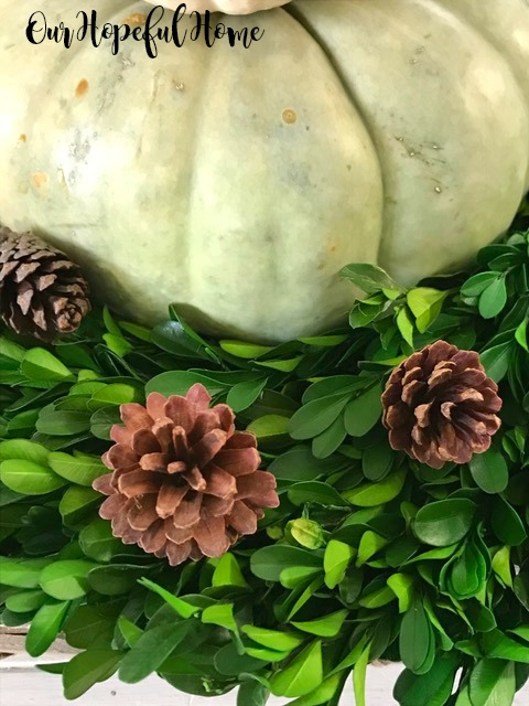 Farmhouse fall decor in tobacco basket with boxwood wreath pumpkins pinecones