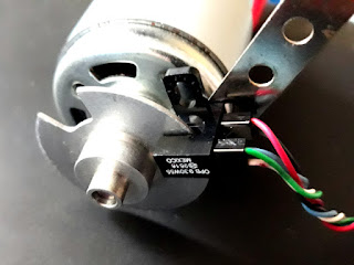 Slotted wheel and optical switch mounted on motor