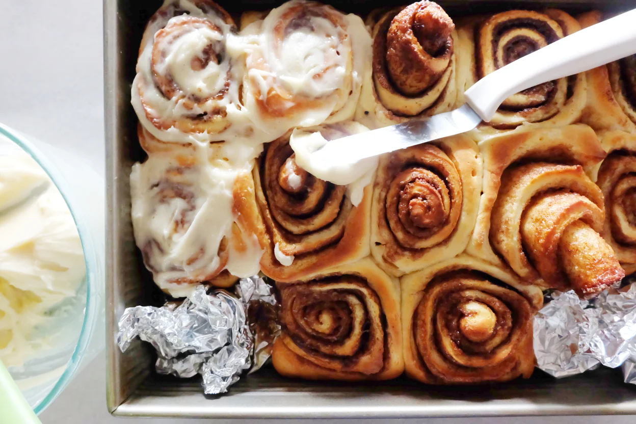 baked cinnamon rolls getting iced