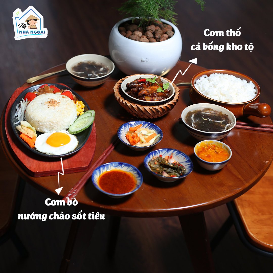 Có thể là hình ảnh về thực phẩm và văn bản cho biết 'Bếp NHÀ NGOẠI Cơm thố cá bống kho tộ Cơm bò nưáng chảo sốt tiêu'