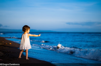 Dragos Dumitrescu, Romania  This little girl speaks to the ocean.  It is a moment of innocence where the soul of a child communicates to all the elements, just like a tiny butterfly flapping its wings.  United Nations World Oceans Day Photo Competition Finalists Gallery 2017 Above Water Seascapes Category – Second Runner Up