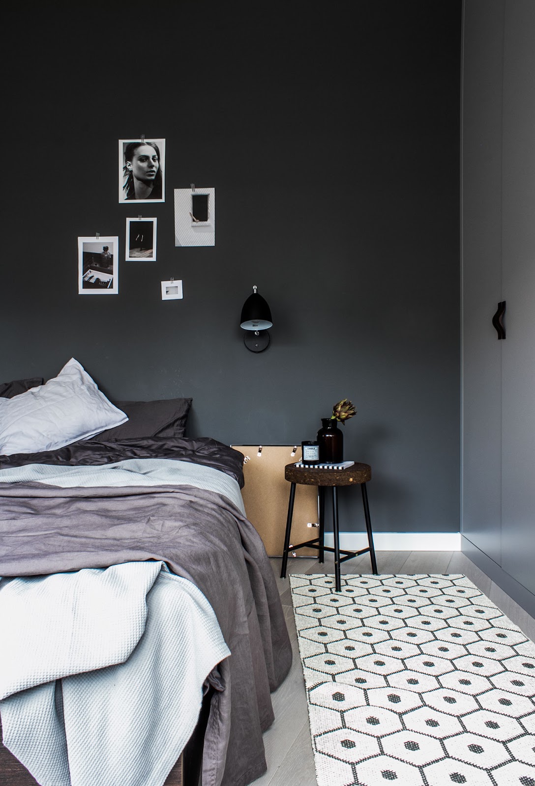 inside of a nordic bedroom, black painted walls, pattern rugs