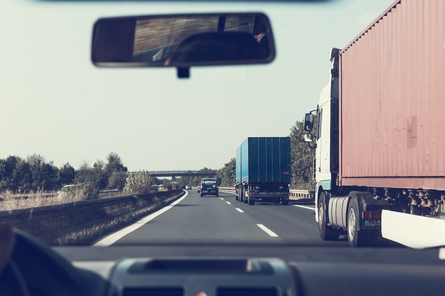 普通自動車の運転席から見たトラックが走る風景