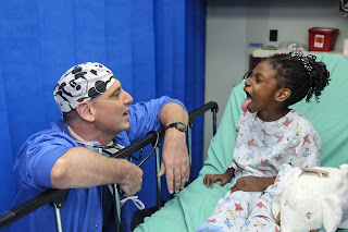 Medico con un niño en cama