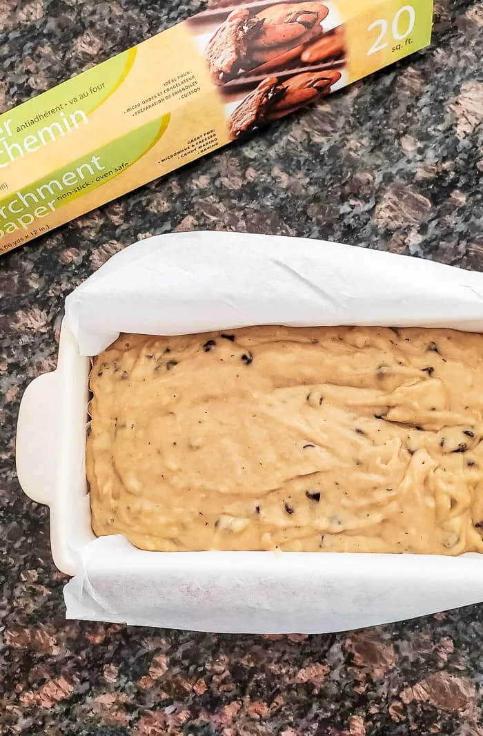 banana bread batter in loaf pan, parchment paper