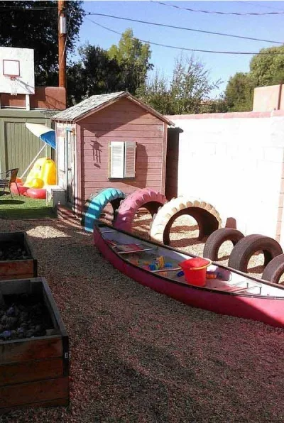 Perahu kayu bekas jadi tempat bermain anak-anak di halaman belakang rumah.