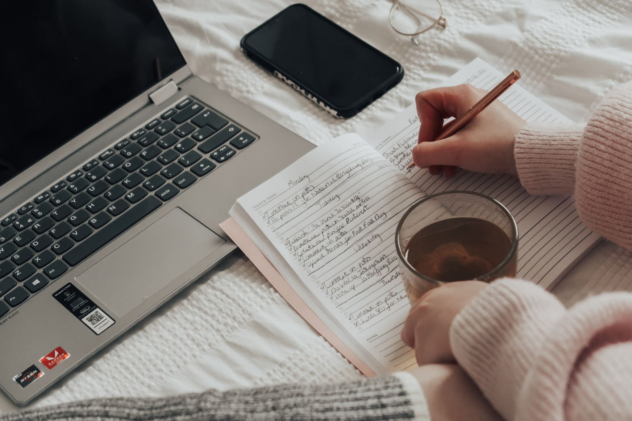 A woman writing in a pink notebook