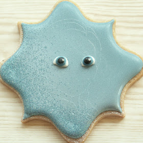 Outline of Anna scribed onto cookie, and royal icing eyes attached, cookie and photo by Honeycat Cookies