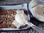 Prajitura Deliciu cu crema si biscuiti Preparare blat din nuca - turnam in tava compozitia