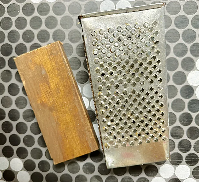 cheese grater and wooden block