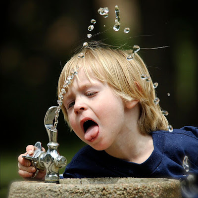 A funny boy drinking water