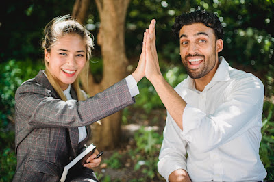 Two confident people hi-fiving