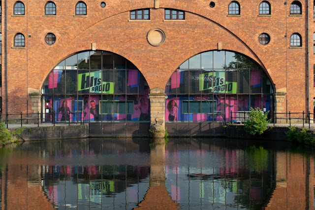 Brick warehouse with entrance for barges reflected in water