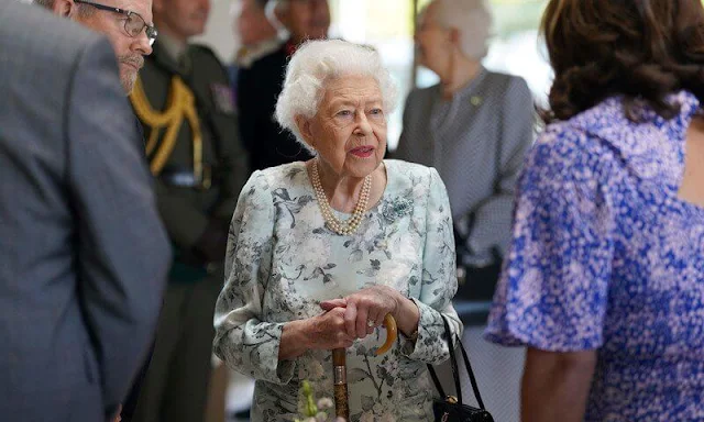 Queen Elizabeth wore a cream and blue floral print midi dress. Princess Anne wore a striped yellow dress