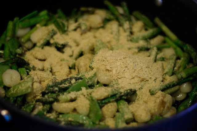 The nutritional yeast in the pan with the vegetables and gnocchi. 