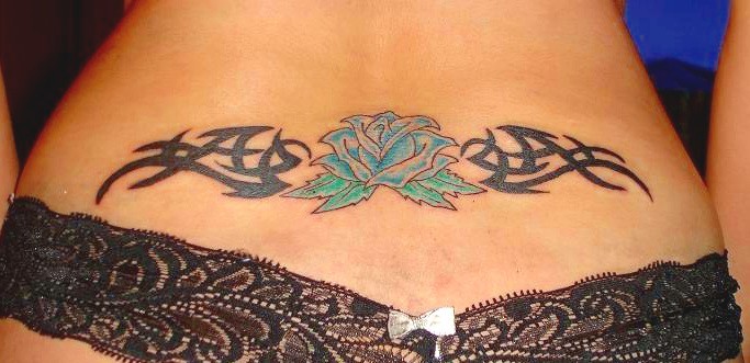 Rose flower and tribal lower back tattoo.