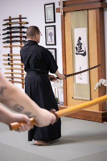 Martial artists holding bokkens while practicing iaido in Ann Arbor