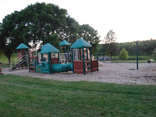 a brown and green play structure at Bacon Creek Park