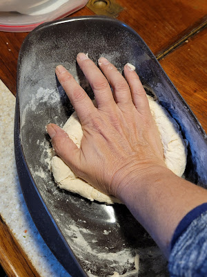A hand is kneading a lump of dough in the Lekue