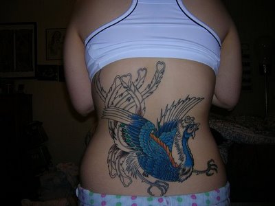 This is a tattoo with the image of the phoenix bird tattoo on the back of