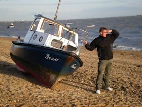 A boat and Richard Gottfried on a beach in Shoeburyness, Essex